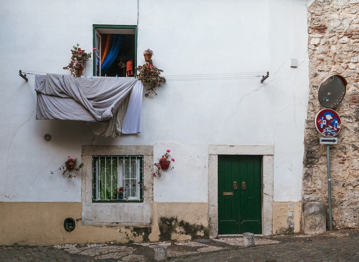 a white building with a green door and window