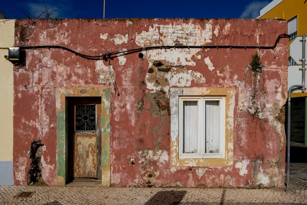 A weathered red building with a wooden door