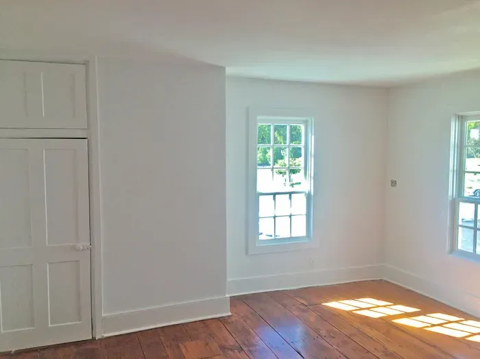 Room with freshly painted white walls and a wooden floor