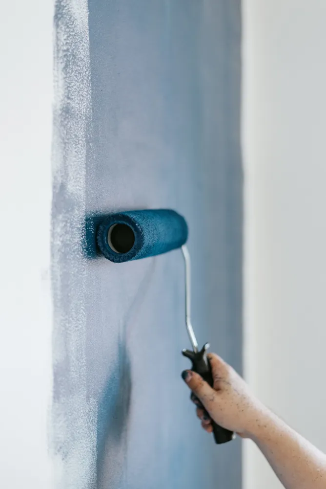 Painter painting an interior wall with a roller